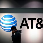 a shopper walks past an AT&T sign outside a store in PA.