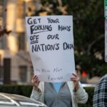 a photo of a protesters in Washington DC with a sign that says "GET YOUR FORKING HANDS OFF OUR NATION'S DATA"