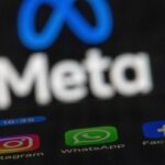 The apps Instagram, Facebook and WhatsApp can be seen on the display of a smartphone in front of the logo of the Meta internet company.