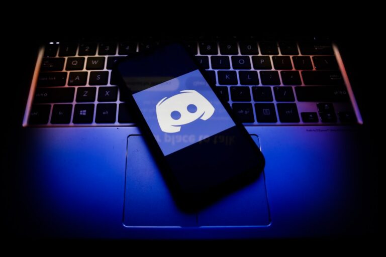 Discord logo displayed on a phone screen and a keyboard.